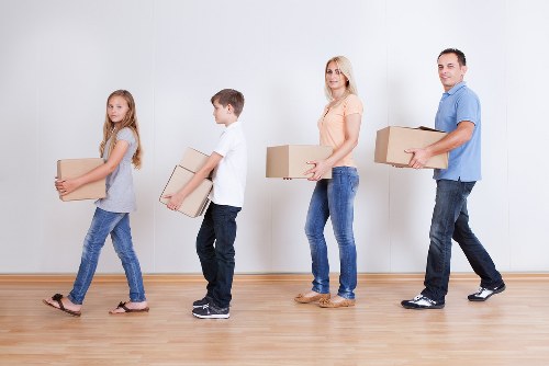 Local moving truck loading furniture and boxes in Queens Park