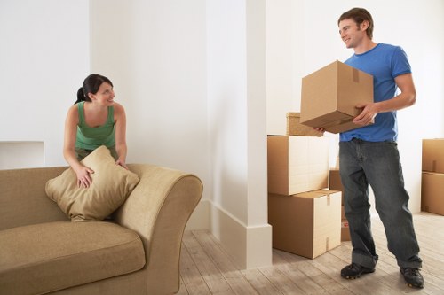 Local movers organising packed boxes in a Queens Park property